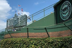 Cubs logo on sign with scoreboard beyond