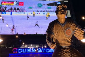 Sandberg statue with video board behind it