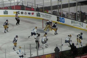 Goalie and players look on as Notre Dame has puck in the corner