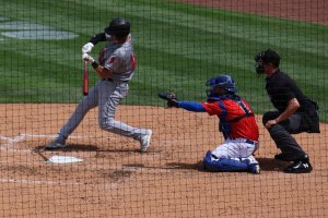 Batter swinging as umpire looks on